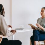 ethnic female psychotherapist listening to black clients explanation